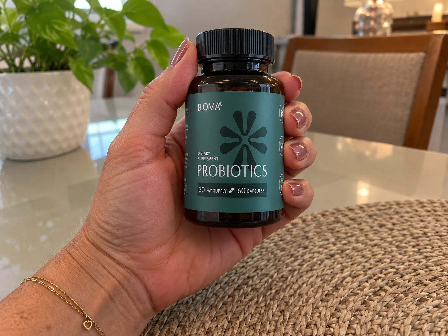 Hand holding a bottle of Bioma Probiotics
